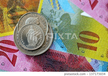 Currency of Switzerland. Banknotes and Swiss franc coins on them. Financial topics in Swiss banking concept. Currency of Switzerland. Banknotes and Swiss franc coins on them. Financial topics in Swiss banking concept. 137173834