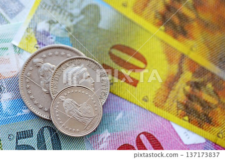 Currency of Switzerland. Banknotes and Swiss franc coins on them. Financial topics in Swiss banking concept. Currency of Switzerland. Banknotes and Swiss franc coins on them. Financial topics in Swiss banking concept. 137173837
