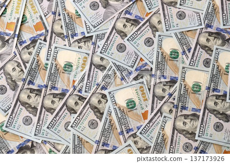 Stacks of hundred dollar bills showcase intricate designs on a flat surface. Money background with Franklin on the 100-dollar note Stacks of hundred dollar bills showcase intricate designs on a flat surface. Money background with Franklin on the 100-dollar note 137173926