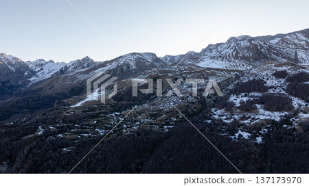 Aerial view of snowy mountain peaks and rocky slopes in the Pyrenees during winter twilight Aerial view of snowy mountain peaks and rocky slopes in the Pyrenees during winter twilight 137173970