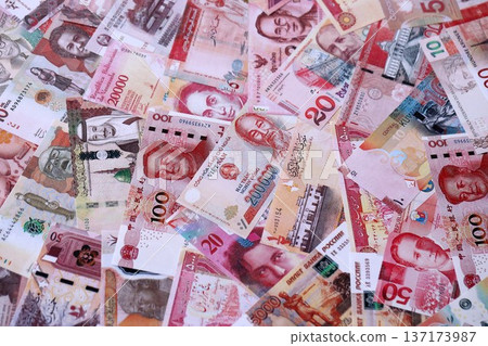 Various currencies money bills banknotes in red color. Many cash bills from different countries in big pile close up. World economy and currency exchange concept Various currencies money bills banknotes in red color. Many cash bills from different countries in big pile close up. World economy and currency exchange concept 137173987