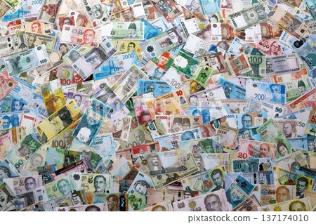 Many banknotes from different countries of the world of different denominations. Big amount of money bills of various currencies. Currency Exchange concept Many banknotes from different countries of the world of different denominations. Big amount of money bills of various currencies. Currency Exchange concept 137174010