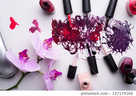 beautiful colorful abstract nail gel polish texture with applicators and orchid on white background beautiful colorful abstract nail gel polish texture with applicators and orchid on white background 137174168