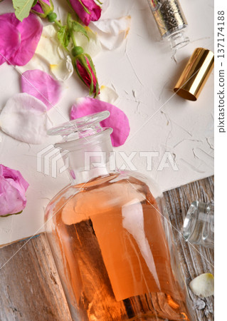 perfume essence around roses settled at authentic provence background. Perfumer, beauty and trendy concept. flat lay perfume essence around roses settled at authentic provence background. Perfumer, beauty and trendy concept. flat lay 137174188