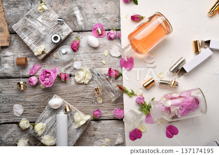 perfume empty bottles and essence around roses settled at authentic provence background. Perfumer, beauty and trendy concept. flat lay perfume empty bottles and essence around roses settled at authentic provence background. Perfumer, beauty and trendy concept. flat lay 137174195