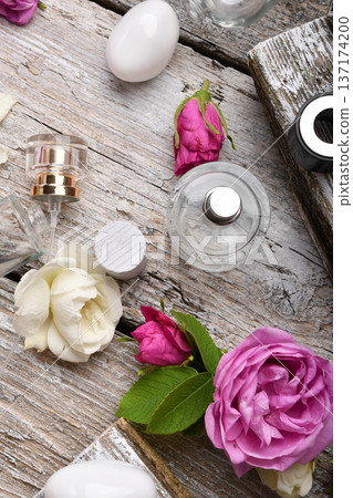 perfume empty bottles around roses settled at authentic provence background. Perfumer, beauty and trendy concept. flat lay perfume empty bottles around roses settled at authentic provence background. Perfumer, beauty and trendy concept. flat lay 137174200