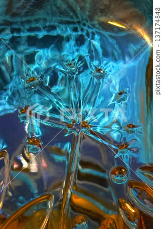 Abstract glass flower in blue and gold tones with translucent details, organic shapes. Teal abstract glass texture, liquid pattern, translucent surface, reflections. Teal abstract design background Abstract glass flower in blue and gold tones with translucent details, organic shapes. Teal abstract glass texture, liquid pattern, translucent surface, reflections. Teal abstract design background 137174848