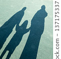 一個成年人和兩個牽著手的孩子的影子 137175337