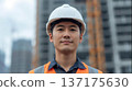 Male construction worker wearing a helmet standing at a construction site 137175630