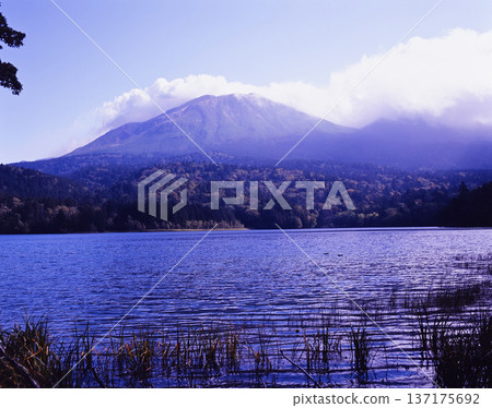 Cloud-covered Mount Meakan and the beautiful blue surface of Lake Onneto Cloud-covered Mount Meakan and the beautiful blue surface of Lake Onneto 137175692