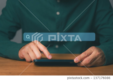 Young man using a smartphone with a search bar, representing online browsing, social media, news, searching products and services, SEO, data research, and internet information discovery at home. Young man using a smartphone with a search bar, representing online browsing, social media, news, searching products and services, SEO, data research, and internet information discovery at home. 137176086