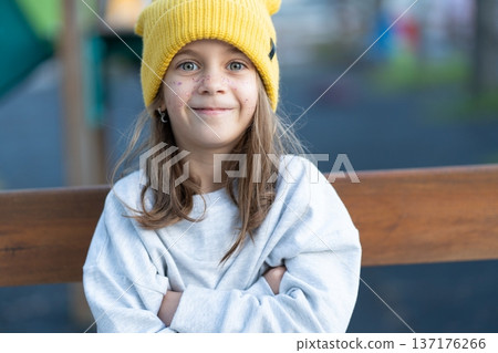 Portrait of happy girl in yellow cap sitting on Portrait of happy girl in yellow cap sitting on 137176266