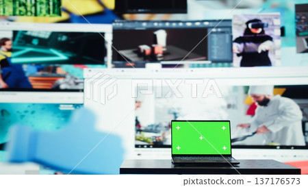 Chroma key notebook and video wall stacked with diverse entertainment media channels. Isolated screen laptop in front of digital backdrop displaying social networks feed activity 137176573