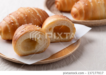 Salt bread (Shio pan) with sea salt flakes on a wooden plate  137177017