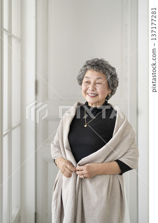 A woman in her 80s smiling by the window 137177281