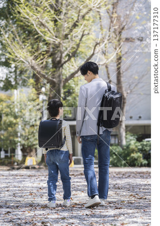 A third-grade boy and his father in his 30s walking side by side A third-grade boy and his father in his 30s walking side by side 137177310