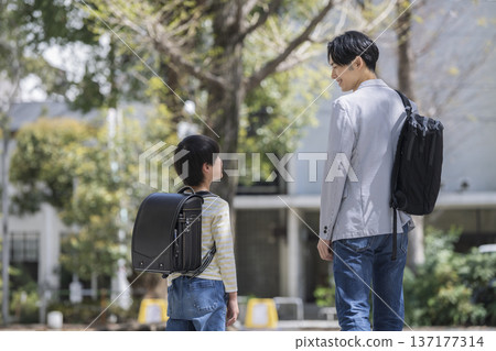 A third-grade boy and his father in his 30s walking side by side A third-grade boy and his father in his 30s walking side by side 137177314