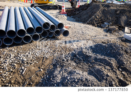 Construction work scene Piping materials and excavator b-1 137177850