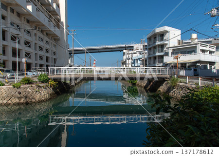 A pedestrian bridge crossing a river in Okinawa and the Tomari Ohashi Bridge crossing the sea 137178612
