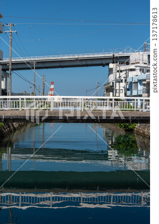 A pedestrian bridge crossing a river in Okinawa and the Tomari Ohashi Bridge crossing the sea 137178613