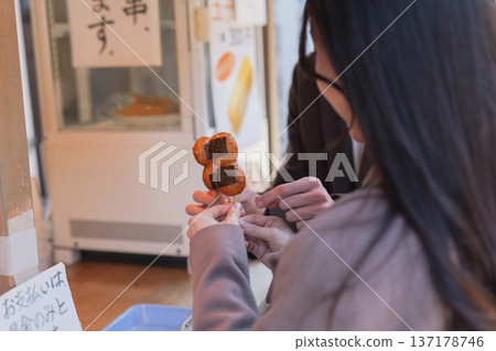 一對情侶邊走邊吃東西的特寫鏡頭,地點在旅遊景點附近。 一對情侶邊走邊吃東西的特寫鏡頭,地點在旅遊景點附近。 137178746