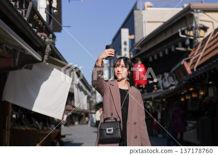 A young woman taking photos of Shibamata's tourist spots with her smartphone A young woman taking photos of Shibamata's tourist spots with her smartphone 137178760