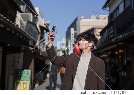 一名男子用智慧型手機拍攝柴又市的旅遊景點。 一名男子用智慧型手機拍攝柴又市的旅遊景點。 137178761
