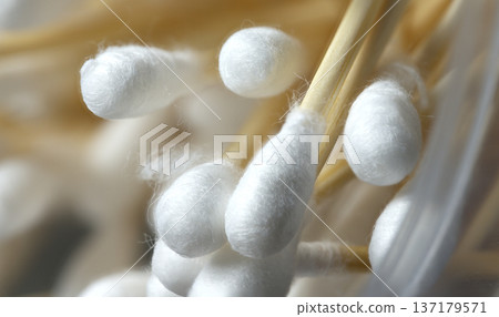 Macro view of a heap of soft cotton buds on sustainable wooden sticks for personal hygiene Macro view of a heap of soft cotton buds on sustainable wooden sticks for personal hygiene 137179571