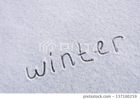 Written WINTER on snow background message ice outdoor on ground in winter. Writing text sign and drawing on field in frozen background. Weather is changing cold season has arrived. Mockup Copy space Written WINTER on snow background message ice outdoor on ground in winter. Writing text sign and drawing on field in frozen background. Weather is changing cold season has arrived. Mockup Copy space 137180259