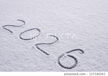Written sketch for new year 2026. Snow background numbers ice outdoor on ground in winter. Writing text sign and drawing on field in nature frozen background. Copy space 137180261