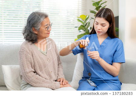 Asian woman nurse or doctor pouring medicine for senior patient. Asian woman nurse or doctor pouring medicine for senior patient. 137180283