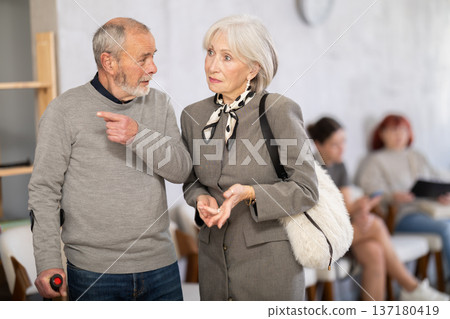 Elderly man and woman talking in reception area of social service Elderly man and woman talking in reception area of social service 137180419