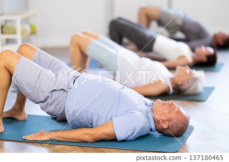 Elderly man doing pilates in group 137180465