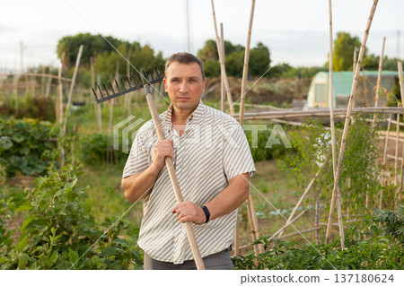 Amateur gardener posing in homestead garden during summer works Amateur gardener posing in homestead garden during summer works 137180624