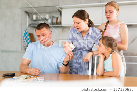 Angry wife with teenage daughters demanding money from upset man 137180653