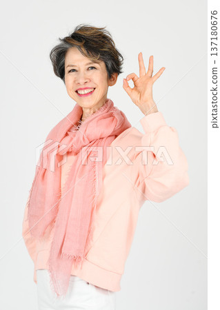 A woman in her 50s making an OK sign on a white background 137180676