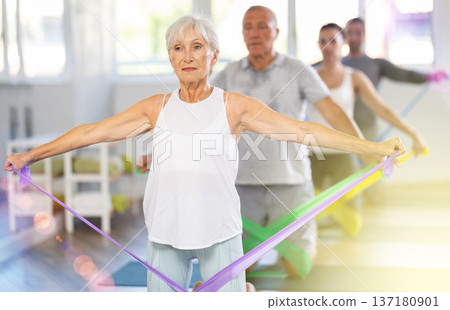 Elderly woman exercises with pilates band 137180901