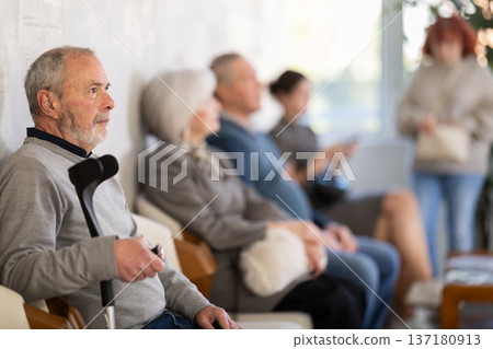 Group of elderly people sitting in chairs in queue to see doctor in lobby medical facility 137180913