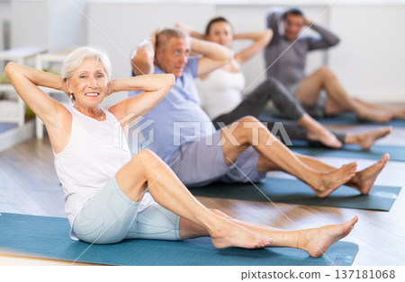 Elderly woman doing pilates in group 137181068