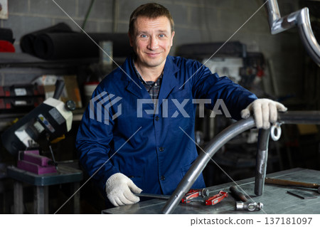 Experienced middle-aged worker posing in professional metalworking workshop Experienced middle-aged worker posing in professional metalworking workshop 137181097