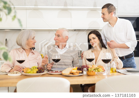 Elderly parents with adult children enjoying family dinner 137181103