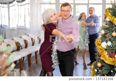 Aged couple during celebration Christmas and New Year dancing cha-cha-cha dance at ballroom 137181108