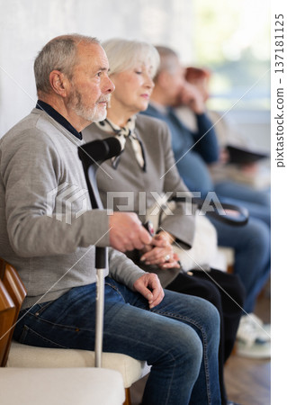 Elderly man waiting in line during visit to medical center Elderly man waiting in line during visit to medical center 137181125