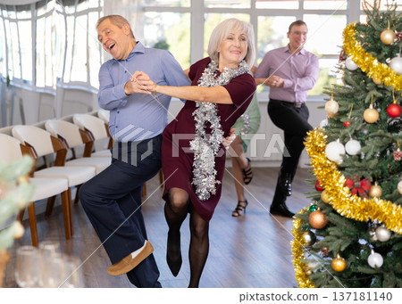 In studio decorated for New Year, elderly man and woman perky dance pair discofox. In studio decorated for New Year, elderly man and woman perky dance pair discofox. 137181140