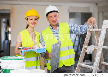 Two workers posing on indoor construction site 137181159
