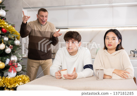 Domestic quarrel during Christmas celebration - father scolds and shouts at young gyuy and girl Domestic quarrel during Christmas celebration - father scolds and shouts at young gyuy and girl 137181285