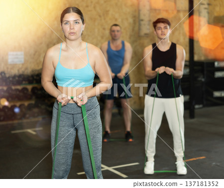 Young woman exercising with elastic loop band at workout Young woman exercising with elastic loop band at workout 137181352