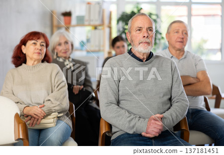 Focused group of students of different ages sitting on chairs and listening lecture in lecture hall Focused group of students of different ages sitting on chairs and listening lecture in lecture hall 137181451