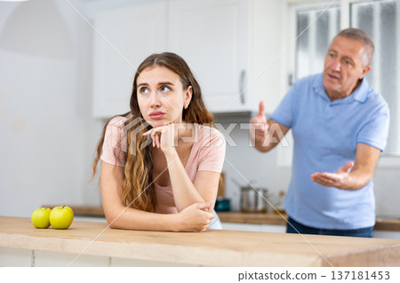 Daughter father scolding and yelling at her in home kitchen Daughter father scolding and yelling at her in home kitchen 137181453