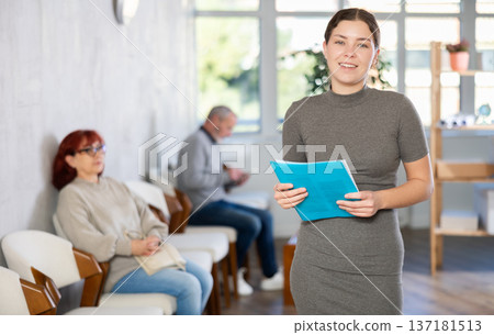 Female social worker inviting senior patients in clinic Female social worker inviting senior patients in clinic 137181513